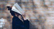woman with book over her head