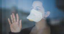 Woman in face mask at window