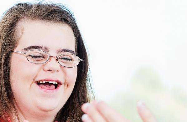 Girl with learning disability smiling and learning