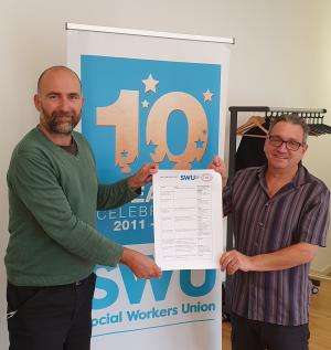 Simon Francis (Campaign Collective) and John McGowan (SWU) hold a copy of the SWU Campaign Fund application form between them