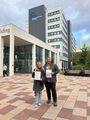David Grimm (right) and Lucy Challoner (left) who are leading the @swstudentsunite campaign hold the jointly signed letter on 28 October 2022. The letter calls for better bursaries for Scottish social work students.