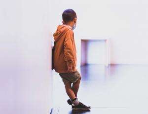 Image by Guillaume de Germain depicting child alone in corridor