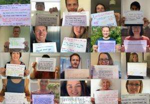 People holding up posters with their messages of support for the independent visitor campaign