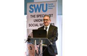 A photo of SWU General Secretary John McGowan speaking in front of a podium